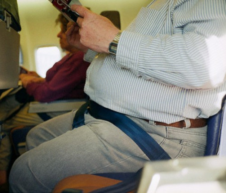 Overweight man sitting in an airplane