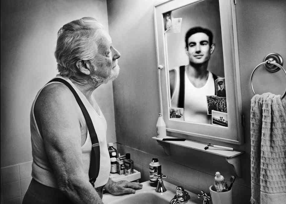 Old man looking at himself in the mirror