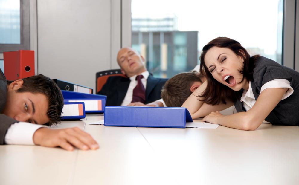Employees yawning at a conference table