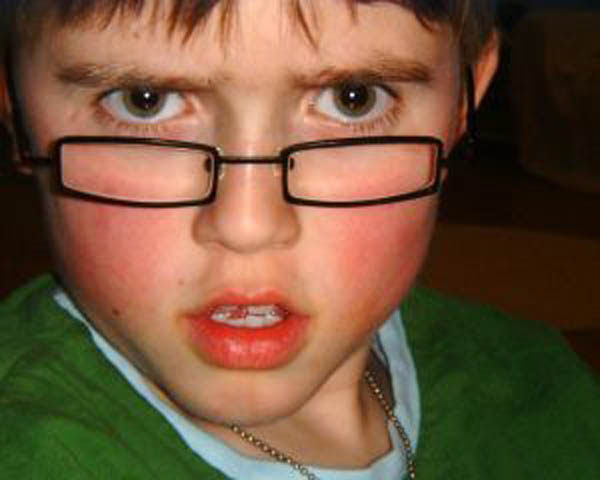Young boy with glasses sneers into the camera