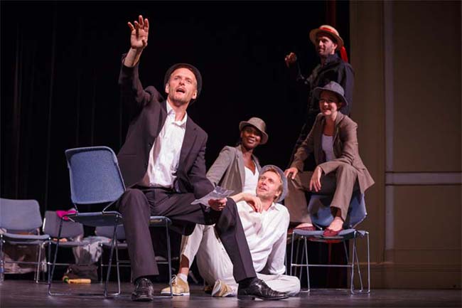 Actors on stage running through screenplays