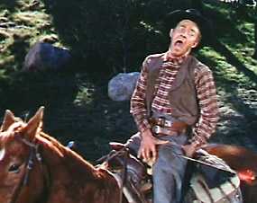 Cowboy sitting on horseback screaming