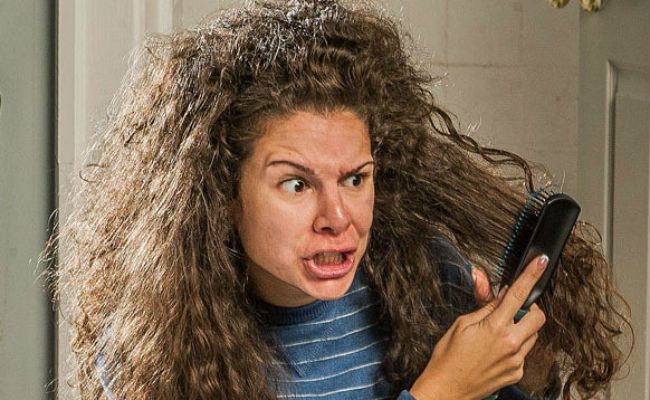 Young girl looking at her frizzy hair