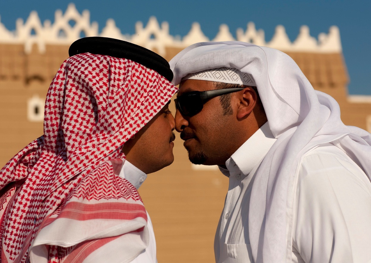 Two Arab men touching noses