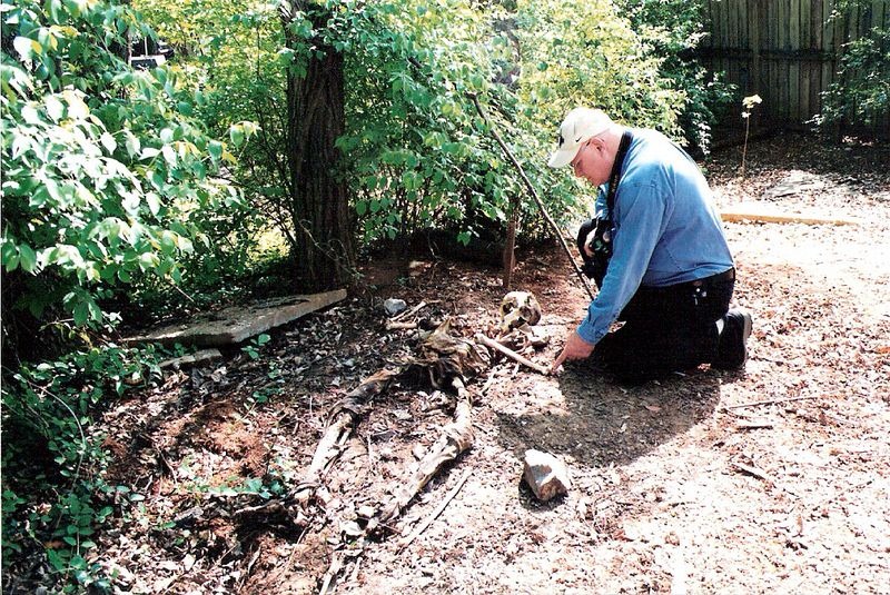 Man kneels over the grave of a deceased man